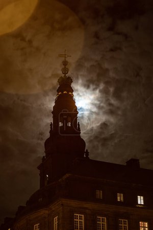 Téléchargez les photos : Copenhague, Danemark Un lever de lune nuageux sur la flèche du palais Christiansborg. - en image libre de droit