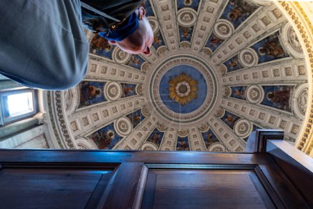 Photo for Copenhagen, Denmark  A man sits at a pew in the Frederiks Church, or Marble Church, and looks up at the dome. - Royalty Free Image