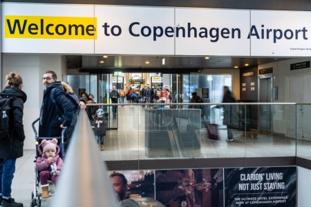 Photo for Copenhagen, Denmark  Pasengers at Copenhagen's Kastrup airport.and a welcome sign. - Royalty Free Image