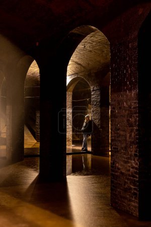 Photo for Copenhagen, Denmark  A woman stands next to  underground arches in the old cisterns in the Frederiksberg district. - Royalty Free Image