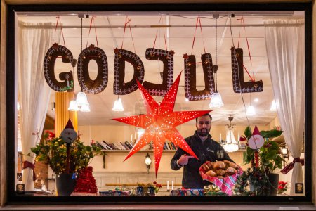 Téléchargez les photos : Stockholm, Suède Une pancarte dans une fenêtre de café dit Joyeux Noël en suédois et le boulanger. - en image libre de droit