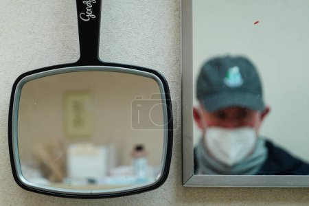 Foto de Solomons, Maryland EE.UU. Un hombre se sienta en el consultorio de un médico y un reflejo en el espejo. - Imagen libre de derechos