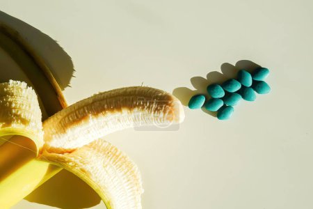 Photo for Impotence pills and a peeled fresh banana - Royalty Free Image