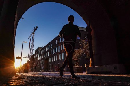 Foto de Copenhague, Dinamarca Un corredor en el antiguo distrito de Carlsberg Brewery al amanecer. - Imagen libre de derechos