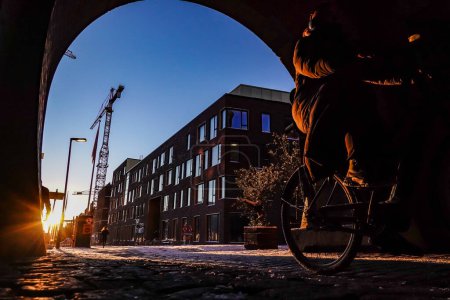 Foto de Copenhague, Dinamarca Un ciclista en el antiguo barrio de Carlsberg Brewery al amanecer. - Imagen libre de derechos