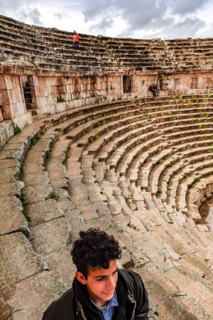 Téléchargez les photos : Jerash, Jordanie Un garçon dans les ruines du célèbre site archéologique gréco-romain Jarash connu sous le nom de Gerasa et de l'amphithéâtre. - en image libre de droit