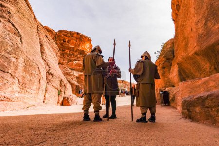 Téléchargez les photos : Petra (Jordanie) Des soldats nabatéens sur le sentier Siq avec des touristes. - en image libre de droit