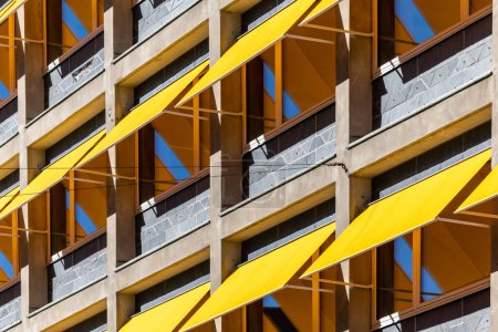 Kopenhagen, Dänemark Ein Bürogebäude mit gelben Markisen über den Fenstern zum Schutz vor der Sonne.