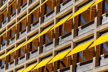 Foto de Copenhague, Dinamarca Un edificio de oficinas con toldos amarillos sobre las ventanas para protegerse del sol. - Imagen libre de derechos