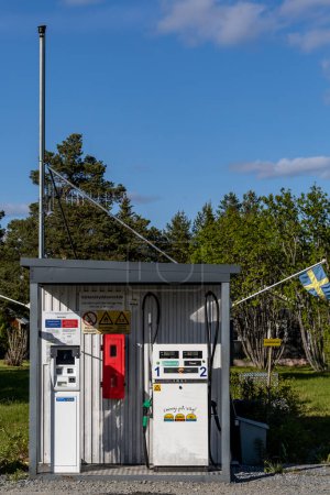 Foto de Kalvtrask, Suecia Una pequeña y anticuada gasolinera con bandera sueca. - Imagen libre de derechos