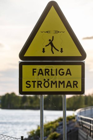 Foto de Skelleftea, Suecia Un cartel en una presa dice en sueco: Corrientes peligrosas - Imagen libre de derechos