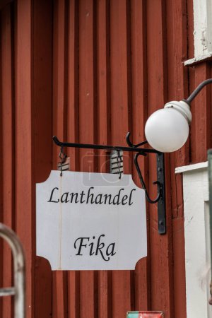 Téléchargez les photos : Skelleftea, Suède Un panneau en suédois pour Lanthandel, ou magasin, et fika, café, dans le quartier historique et culturel Bonnstan. - en image libre de droit