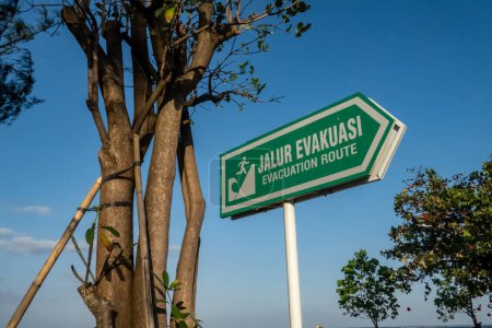 Téléchargez les photos : Sanur, Bali, Indonésie Un panneau de sécurité vert sur la plage indique un itinéraire d'évacuation en cas de tsunami. - en image libre de droit