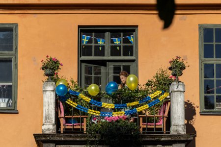Téléchargez les photos : Stockholm, Suède 15 Juin, 2023 Un balcon festonné au centre-ville avec des ballons bleus et jaunes et des fleurs. - en image libre de droit