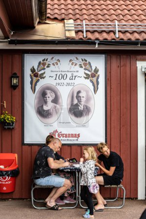 Téléchargez les photos : Nusnas, Suède 13 juillet 2023 Une famille assise devant un atelier de fabrication de chevaux Dala. - en image libre de droit