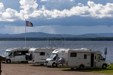 Téléchargez les photos : Nusnas, Suède 13 juillet 2023 Une rangée de véhicules de camping stationnés sur la rive du lac Siljan en été. - en image libre de droit