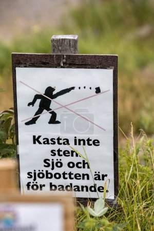 Photo for Leksand, Sweden A sign on the beach in Swedish says in English translation: "Don't throw stones. Beach is for bathing." - Royalty Free Image