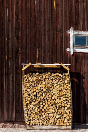 Téléchargez les photos : Nusnas, Suède Une pile de bois de chauffage empilé contre la façade d'une grange rouge. - en image libre de droit