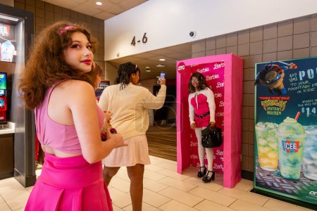 Téléchargez les photos : Lexington Park, maryland, États-Unis 3 août 2023 Les cinéphiles dans le hall d'un cinéma prennent des selfies avec le matériel de marketing Barbie. - en image libre de droit