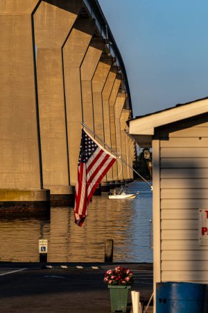 Foto de Solomons, Maryland, EE.UU. agosto 3, 2023 Un pescador en una pequeña lancha pesca bajo el puente de las Salomón al amanecer. - Imagen libre de derechos