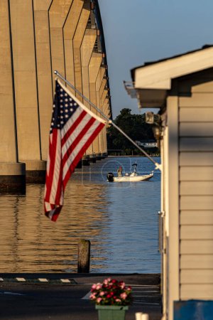 Foto de Solomons, Maryland, EE.UU. agosto 3, 2023 Un pescador en una pequeña lancha pesca bajo el puente de las Salomón al amanecer. - Imagen libre de derechos