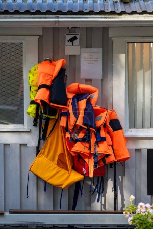 Photo for Stockholm, Sweden Lifejackets hanging in a marina and a sign says in Swedish: "Lifejacksets on loan for small children." - Royalty Free Image