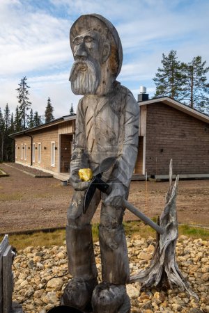Foto de Tankavaara, Finlandia Oct 7, 2023 Una estatua de un minero de oro con un hacha de pico sosteniendo una pieza de oro en un museo de oro al aire libre. - Imagen libre de derechos