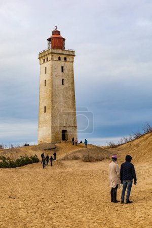Téléchargez les photos : Le phare de Rubjerg Knude, Danemark Nov 1, 2023 Une vue du célèbre phare de Rubjerg Knude qui a été déplacé en raison de l'érosion des dunes et de l'eau en 2018, et des personnes marchant. - en image libre de droit
