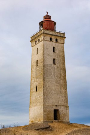Téléchargez les photos : Phare de Rubjerg Knude, Danemark Une vue sur le célèbre phare de Rubjerg Knude qui a été déplacé en raison de l'érosion des dunes et de l'eau en 2018, et les gens qui marchent. - en image libre de droit