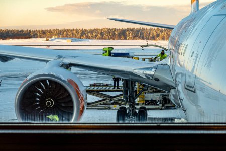 Photo for Stockholm, Sweden Nov 29, 2023 A plane on the snowy tarmac at Arlanda Airport. plane receives baggagae and gets checked. - Royalty Free Image