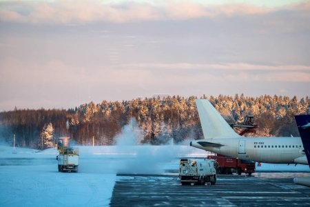 Téléchargez les photos : Stockholm, Suède Nov 29, 2023 Un avion sur l'aire de trafic enneigée de l'aéroport d'Arlanda se dégivre. - en image libre de droit