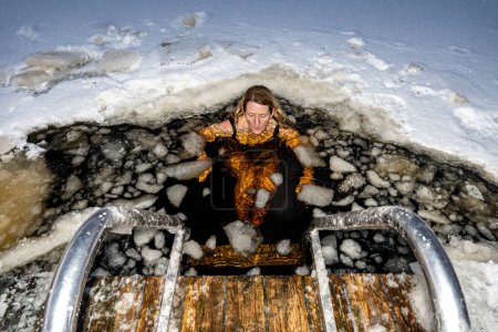 Téléchargez les photos : Stockholm, Suède Une femme se baignant sur la glace d'un quai dans un lac gelé. - en image libre de droit