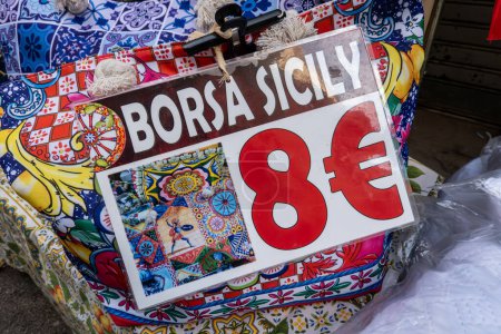Téléchargez les photos : Palerme, Sicile, Italie 14 janv.2024 Une collection de tissus authentiques siciliens à vendre à un marché de rue et Borsa Siciy signe avec 8 Euro prix. - en image libre de droit