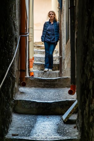 Téléchargez les photos : Cefalu, Sicile, Italie Une touriste se tient dans une ruelle étroite appelée Vicolo Monteleone. - en image libre de droit