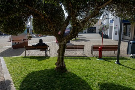 Téléchargez les photos : Sicilia Outlet Village, Sicile, Italie 17 janv.2024 Un homme est assis sur un banc au centre commercial Sicilia Outlet Village au milieu de l'île. - en image libre de droit