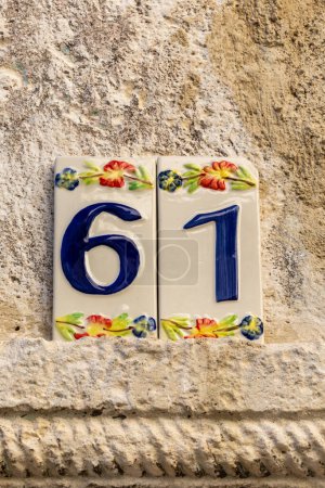 Goriano Sicoli, Italien Eine kunstvolle Hausnummer 61 an der Fassade eines Hauses.