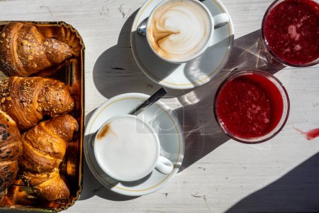 Raiano, Italien Ein Tisch mit frischen Croissants, Cappucinos und frisch gepresstem Blutorangensaft auf einem Cafétisch.