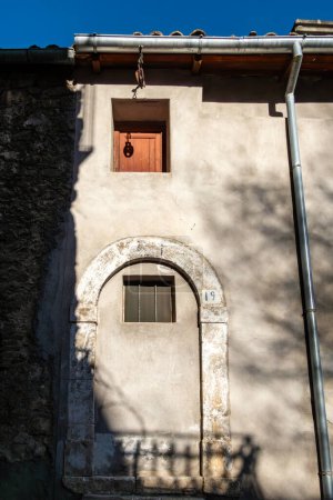 Pacentro, Italien Ein sonnendurchfluteter Bogen an der Fassade eines alten Gebäudes.