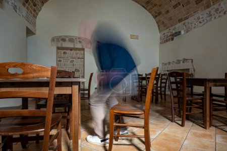 Pacentro, Italien Ein Mann sitzt in einer alten Taverne. Tisch und Stühle aus Holz mit gewölbter Ziegeldecke