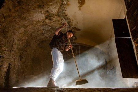Roccamorice, Italy A man sweeps a dirt floor Eremo di San Bartolomeo sanctuary, an old monastery.