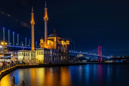 Estambul, Turquía Una vista nocturna de la mezquita de Ortaky y el puente de los mártires del 15 de julio.