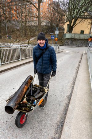 Stockhom, Schweden Ein Mann schiebt eine Schubkarre mit Glasflaschen, die von Tauchern im Palsundet-Kanal in der Stockholmer Innenstadt aufgelesen werden.