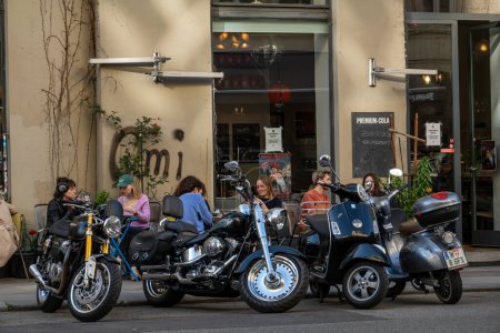 Foto de Viena, Austria 5 de abril de 2024 Personas en un café al aire libre rodeado de motocicletas y bicicletas en Gumpendorfer Strasse. - Imagen libre de derechos