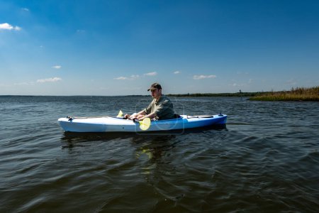 Broomes Island, Maryland USA Ein junger Mann paddelt an einem sonnigen Tag auf dem Patuxent River.