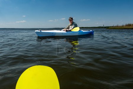 Broomes Island, Maryland USA Ein junger Mann paddelt an einem sonnigen Tag auf dem Patuxent River.