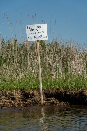 Broomes Island, MAryland USA A handwritten post on a tidal wetlands island says Keep out no hunting.