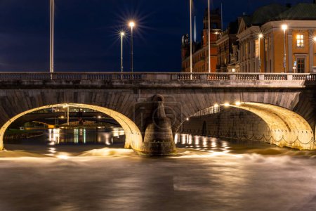 Stockholm, Schweden Frischwasser aus dem Malarensee rauscht nachts unter der Norrbro-Brücke im Norrstrom-Gewässer in die Ostsee.