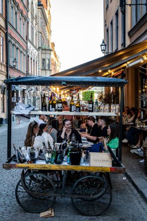 Foto de Estocolmo, Suecia 17 de mayo de 2024 Personas sentadas afuera en un restaurante en el casco antiguo o Gamla Stan. - Imagen libre de derechos