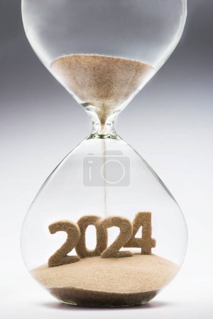 Téléchargez les photos : Nouvel An 2024 concept avec sablier tombant sable prenant la forme d'un 2024 - en image libre de droit