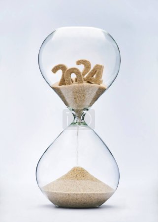 Téléchargez les photos : Nouvel An 2025 concept. Concept d'épuisement du temps avec sablier tombant de sable à partir de 2024. - en image libre de droit